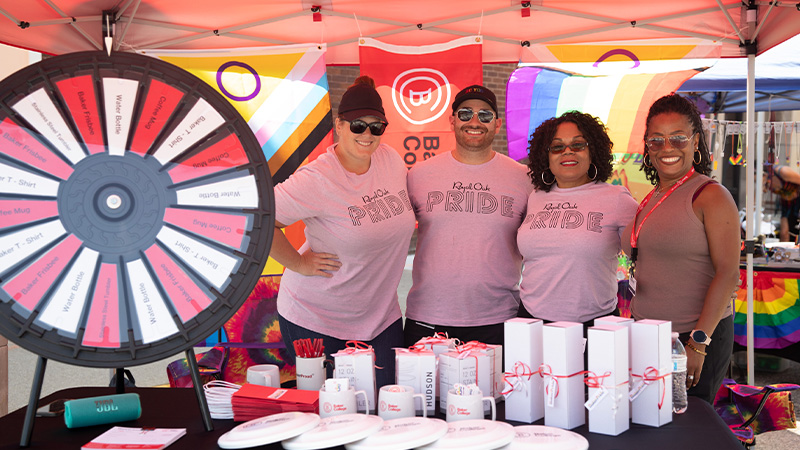 Baker Colleeg employees hosting a table during a Royal Oak Pride event.