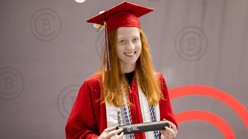 Young graduate poses with her degree.