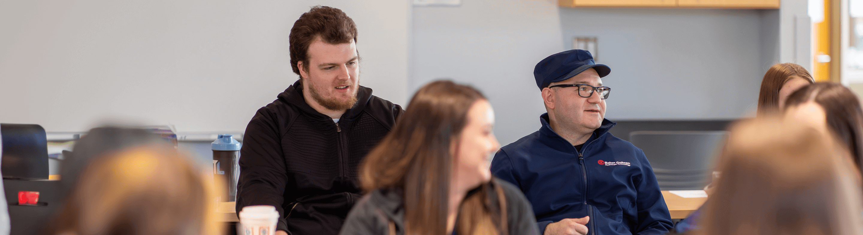 A group of students in a classroom talking to each other.