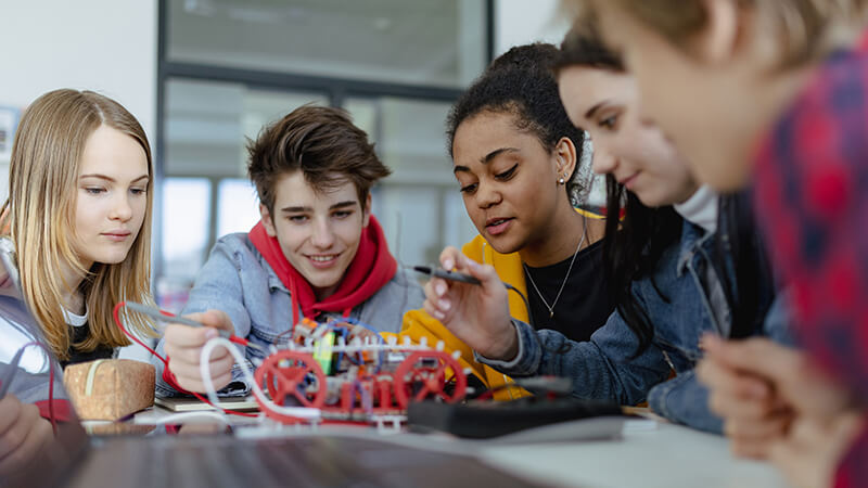 A group of kids work together on a robotics project.
