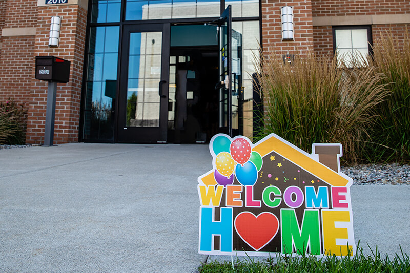 A colorful Welcome Home sign outside of Baker College student housing.