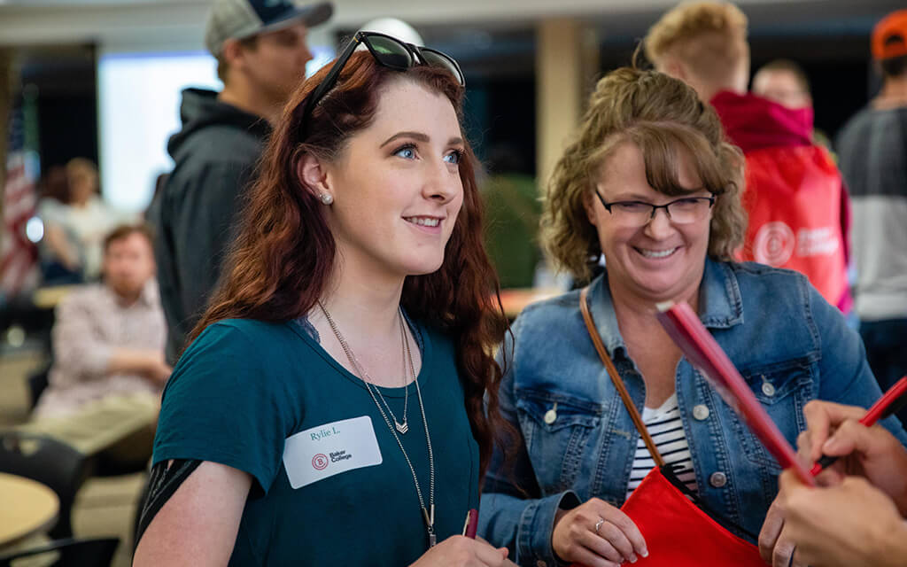 A student and parent talk to an advisor