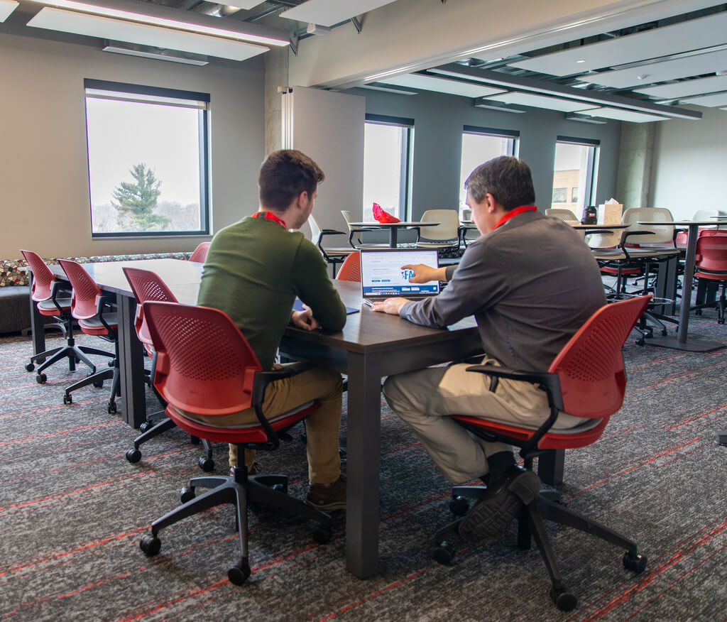 A staff member helps a student apply for financial aid.