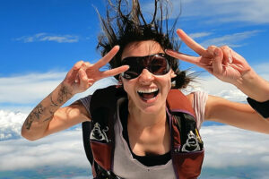 A woman smiling at the camera while skydiving